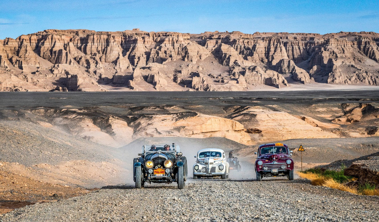 multiple cars in a dessert landscape during Peking to Paris